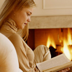 woman reading book by fire